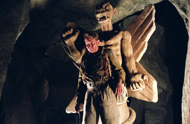 Exorcist: The Beginning [2004] Stellan Skarsgard standing in front of the Pazuzu statue in an underground church scene
