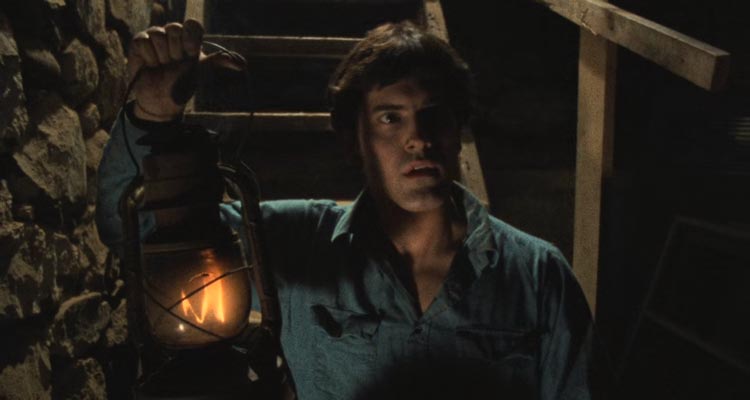 The Evil Dead 1981 Movie Scene Bruce Campbell as Ash going into the cellar of the house