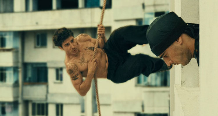 District 13 AKA Banlieue 13 Movie 2004 Scene David Belle as Leuto holding a rope while running on the side of a building preparing to kick a guy in the head