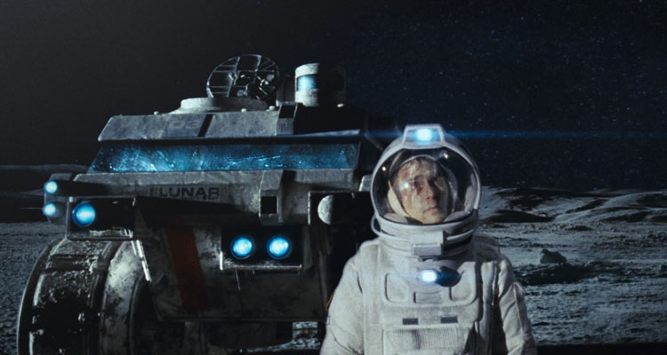 Moon Movie 2009 Scene Sam Rockwell as Sam Bell in his astronaut suit with the rover behind him walking on the surface of moon