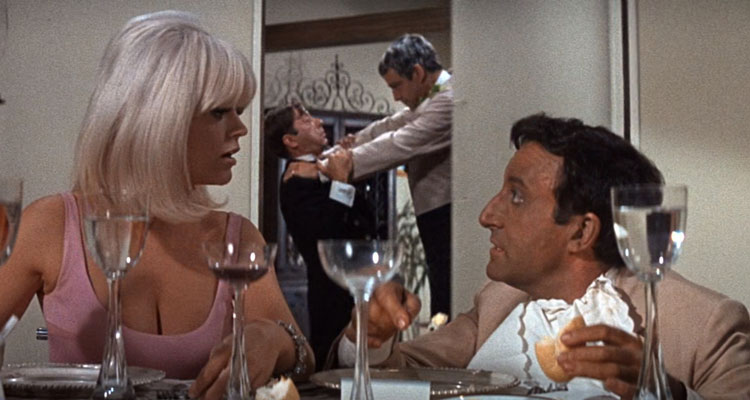 The Party 1968 Movie Scene Carol Wayne as June wearing a pink dress with a big cleavage and Peter Sellers as Hrundi V. Bakshi during dinner