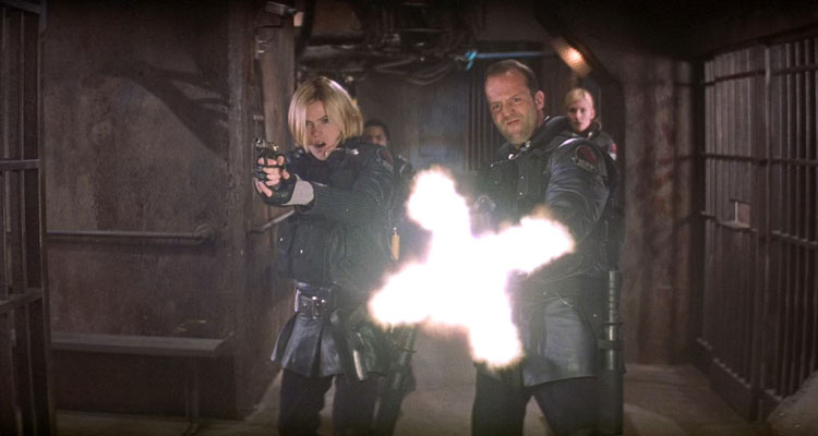 Ghosts Of Mars Movie 2001 Scene Jason Statham as Jericho firing off a machine gun at the demonically possesses miners