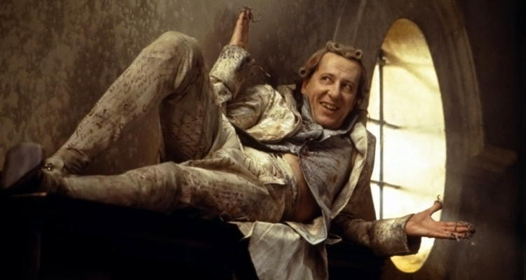 Quills 2000 Movie Geoffrey Rush as Marquis de Sade laying on a cupboard with his arms stretched