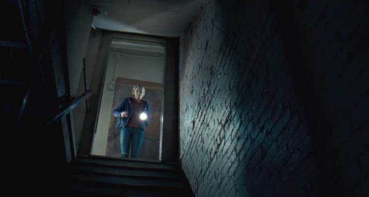 The Innkeepers 2011 Movie Scene Sara Paxton as Claire using a flashlight to look into the basement after hearing strange noises