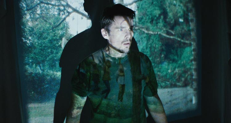 Sinister 2012 Movie Scene Ethan Hawke as Ellison hearing something strange while playing the video of four people hanging themselves