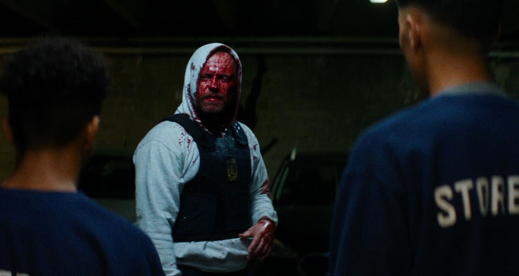 Shorta AKA Enforcement 2020 Movie Jacob Lohmann with a face covered in blood wearing a bulletproof west and a hoodie