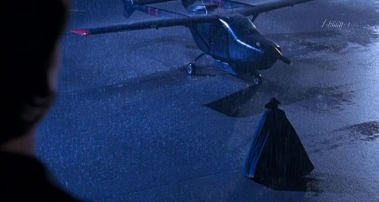 The Night Flier 1997 Movie Scene Michael H. Moss as Dwight Renfield walking towards his black Cessna Skymaster wearing a large cape in the rain