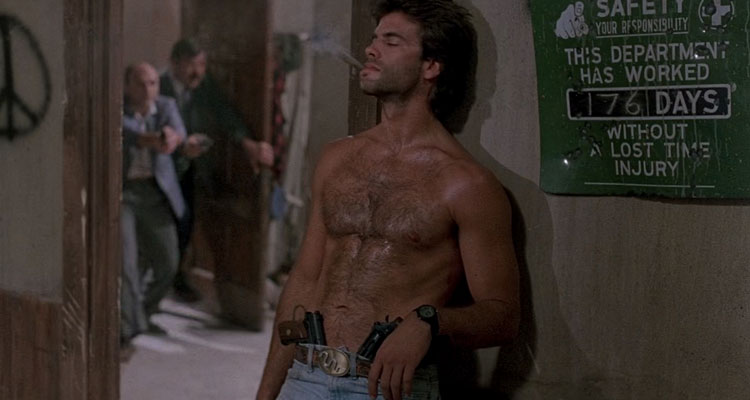 Snake Eater 1989 Movie Scene Lorenzo Lamas as Jack Soldier Kelly without a shirt, smoking a cigar with two guns in his jeans