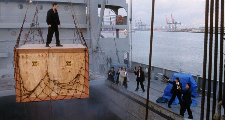 Drive 1997 Movie Scene Mark Dacascos as Toby Wong standing on a wooden crate with the bad guys pointing their guns at him