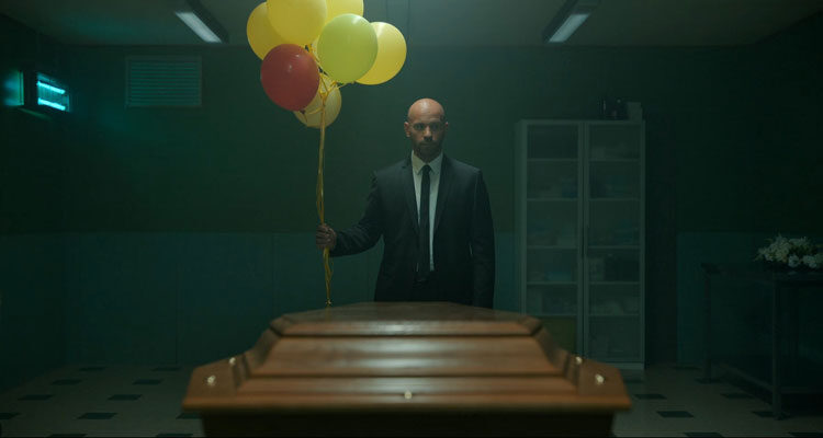 Restless Movie 2022 Scene Franck Gastambide as Thomas holding a bunch of balloons in front of a coffin