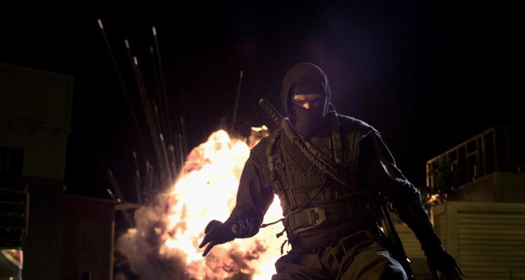 Ninja 2 Shadow of a Tear 2013 Movie Scene Scott Adkins as Casey dressed as ninja with an explosion going off behind him