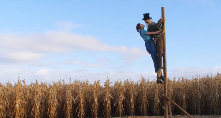 Pearl 2022 Movie Scene Mia Goth as Pearl in a cornfield kissing scarecrow