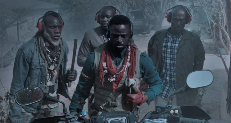 Saloum 2022 Movie Scene Yann Gael as Chaka and Roger Sallah as Rafa holding a meat cleaver about to go on a quad bike