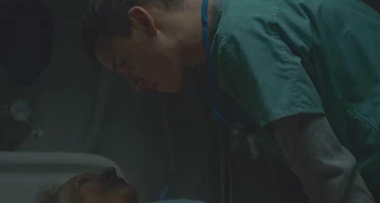 The Good Nurse 2022 Movie Scene Eddie Redmayne as Charlie Cullen staring into the eyes of the recently deceased woman in a hospital