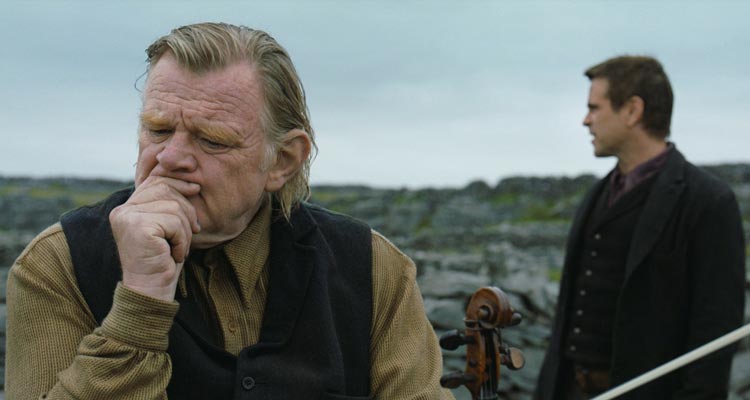 The Banshees of Inisherin 2022 Movie Scene Brendan Gleeson as Colm holding his violin and thinking with Colin Farrell as Padraic standing in the background