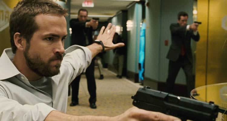 Smokin Aces 2006 Movie Scene Ryan Reynolds as Messner holding a gun during a shootout in the hotel and showing other FBI officers to hold