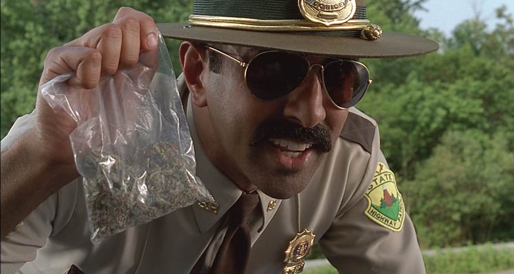 Super Troopers 2001 Movie Scene Jay Chandrasekhar as Ramathorn holding a bag of weed after he pulled over three teenagers in a car