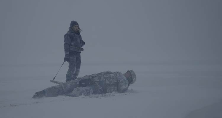 Black Crab 2022 Movie Scene Noomi Rapace as Caroline Edh holding a sniper rifle after she shot Jakob Oftebro as Nylund on the ice