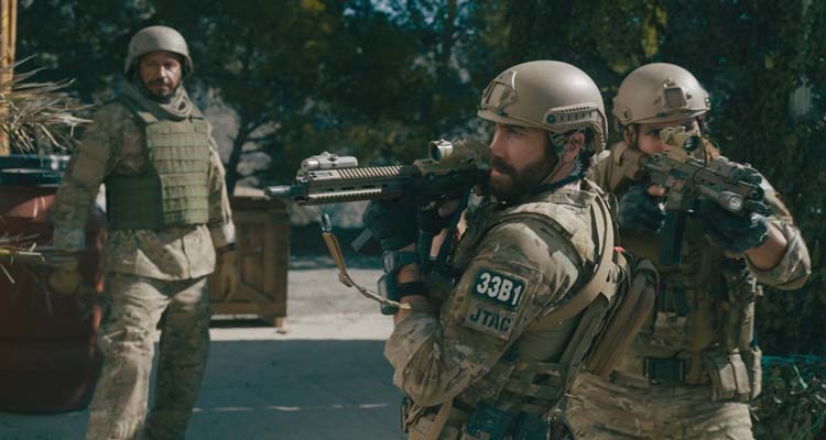 Guy Ritchies The Covenant 2023 Movie Scene Jake Gyllenhaal as John Kinley holding his gun while Dar Salim as Ahmed takes in the situation