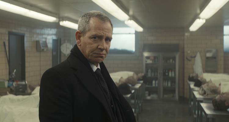 To Catch A Killer 2023 Movie Scene Ben Mendelsohn as Lammark in the morgue next to the bodies of the victims of the mass shooting