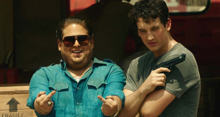 War Dogs 2016 Movie Scene Jonah Hill as Efraim Diveroli and Miles Teller as David Packouz posing for a picture in front of a truck after a successful delivery of weapons