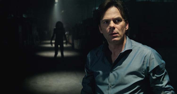 Lights Out 2016 Movie Scene Billy Burke as Paul looking into the light with a dark figure standing in shadows behind him