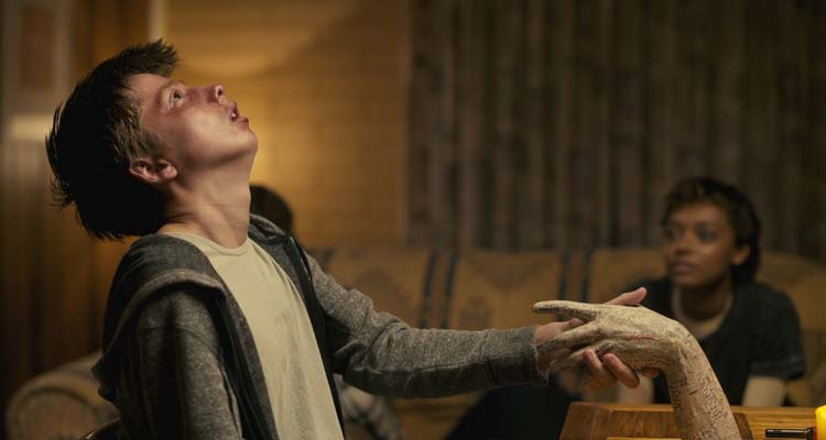 Talk to Me 2022 Movie Scene Joe Bird as Riley holding the embalmed hand and letting the ghosts inhabit him