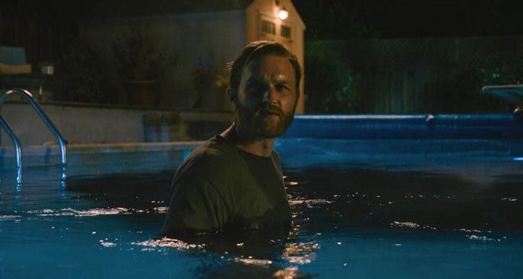 Night Swim 2024 Movie Scene Wyatt Russell as Ray Waller slowly going deeper into the haunted pool to save his family