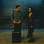 Past Lives 2023 Movie Scene Greta Lee as Nora/Na Young and Teo Yoo as Hae Sung saying goodbye as he flies back to South Korea