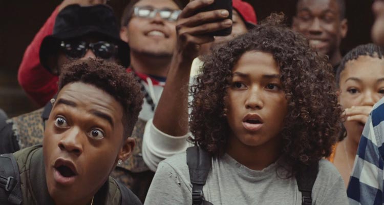 Kicks 2016 Movie Scene Jahking Guillory as Brandon and Christopher Meyer as Rico watching a fight at school with Brandon looking at the guys Air Jordan shoes