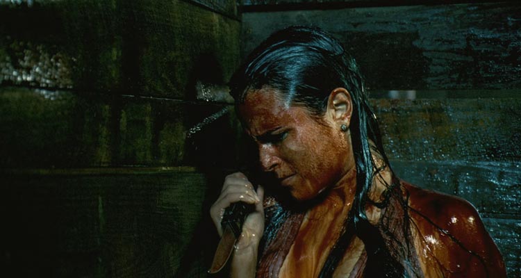 The Texas Chainsaw Massacre The Beginning 2006 Movie Scene Jordana Brewster as Chrissie covered in blooding, hiding in the slaughterhouse and holding a knife