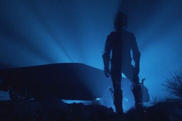 The Wraith 1986 Movie Scene A mysterious man in a cyberpunk suit and a helmet standing in front of a futuristic car that's actually Dodge M4S Turbo Interceptor