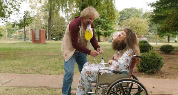 Dumb and Dumber To 2014 Movie Scene Jeff Daniels as Harry holding a catheter bag full of piss in his mouth while he fixes another one for Jim Carrey as Lloyd