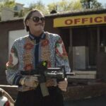 Lowlife 2017 Movie Scene Mark Burnham as Teddy Bear Haynes firing an automatic rifle at the motel