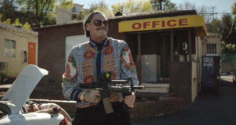 Lowlife 2017 Movie Scene Mark Burnham as Teddy Bear Haynes firing an automatic rifle at the motel