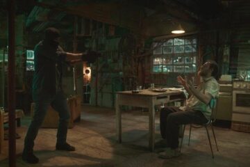 Adagio 2023 Movie Scene Adriano Giannini as Vasco holding a gun pointed at Valerio Mastandrea as Polniuman in his house and asking where is Manuel