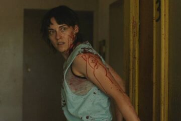 Love Lies Bleeding 2024 Movie Scene Kristen Stewart as Lou covered in blood after Jackie shot Daisy