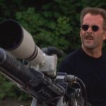 The Jackal 1997 Movie Scene Bruce Willis as The Jackal standing next to a huge sniper rifle that's actually a Browning M2 heavy machine gun