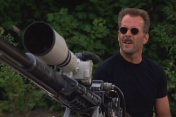 The Jackal 1997 Movie Scene Bruce Willis as The Jackal standing next to a huge sniper rifle that's actually a Browning M2 heavy machine gun