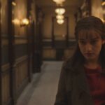 Apartment 7A 2024 Movie Scene Julia Garner as Terry Gionoffrio in the hallway of her building hearing strange noises