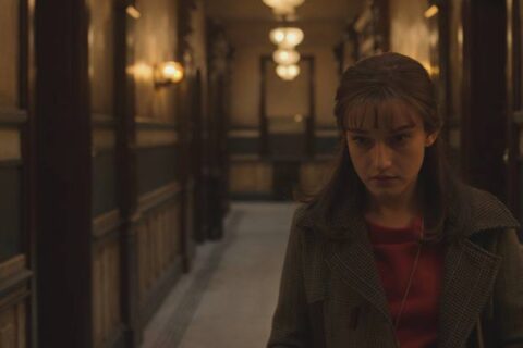 Apartment 7A 2024 Movie Scene Julia Garner as Terry Gionoffrio in the hallway of her building hearing strange noises