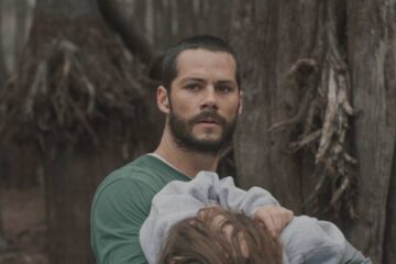 Caddo Lake 2024 Movie Scene Dylan O'Brien as Paris holding the body of a lost girl in the woods