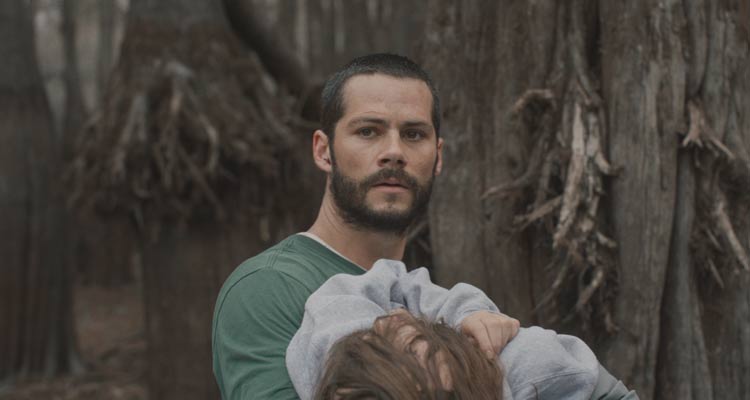 Caddo Lake 2024 Movie Scene Dylan O'Brien as Paris holding the body of a lost girl in the woods