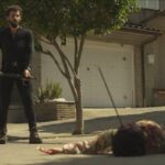 Apocalypse Z The Beginning of the End 2024 Movie Scene Francisco Ortiz as Manel standing over the body of a zombie he just killed on the street