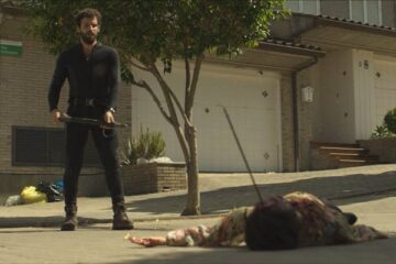 Apocalypse Z The Beginning of the End 2024 Movie Scene Francisco Ortiz as Manel standing over the body of a zombie he just killed on the street