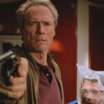 In The Line Of Fire 1993 Movie Scene Clint Eastwood as Frank Horrigan holding a gun while Dylan McDermott as Al D'Andrea is struggling to breathe behind him