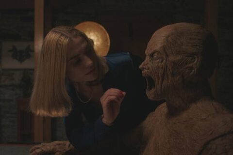 Oddity 2024 Movie Scene Caroline Menton as Yana about to put her hand in the mouth of the Golem creature