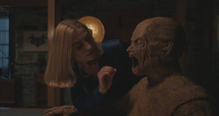 Oddity 2024 Movie Scene Caroline Menton as Yana about to put her hand in the mouth of the Golem creature