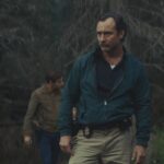 The Order 2024 Movie Scene Jude Law as Terry Husk looking for a white supremacist gang murder site in the woods