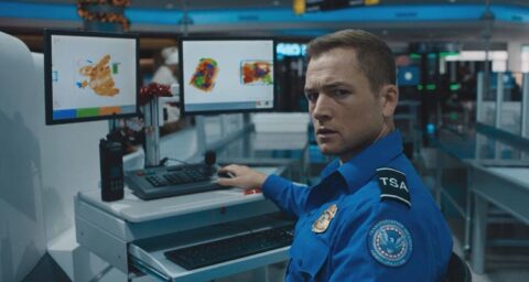 Carry On 2024 Movie Scene Taron Egerton as Ethan Kopek, a TSA agent working at an airport realizing he has to let a bomb through his scanner onto a flight